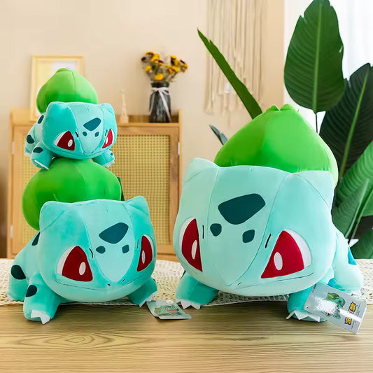 Three plush toys resembling Bulbasaur from Pokémon. Group of differnt size Bulbasaur plushies. 