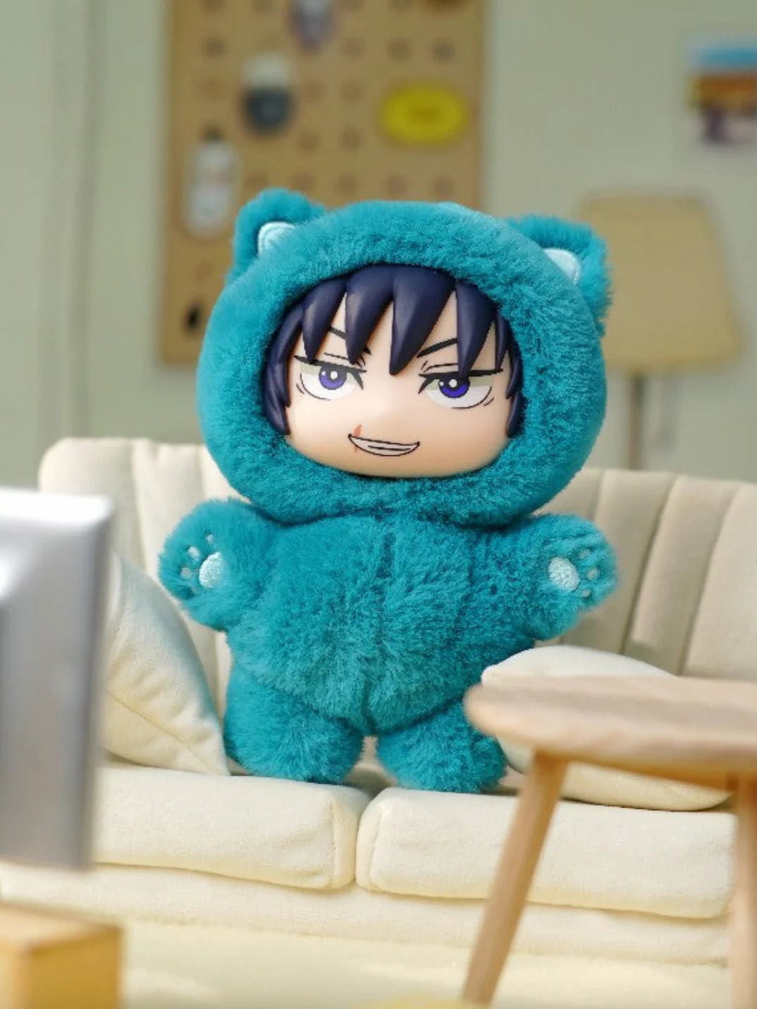 Plush toy with a character's face inside a blue hooded outfit on a couch. Toji Fushiguro Cat Ear Plushie