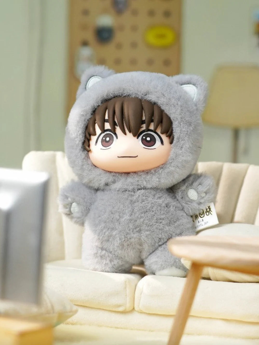 Plush toy with cartoon character design sitting on a couch. Yu Haibara Cat Ear Plushie. Cute Grey plushie Haibara